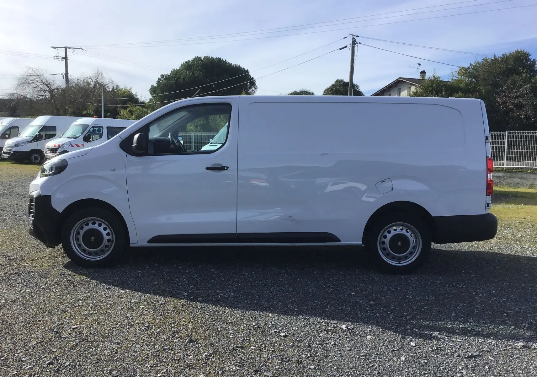 Vue de profil côté gauche d’un FIAT Scudo Fourgon blanc 2024, fourgon utilitaire avec garde au sol réhaussée et jantes acier.