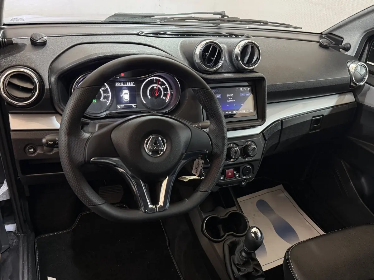 Vue intérieure centrée sur le tableau de bord et le volant de l'AIXAM AMBITION 0.5 CROSSOVER PREMIUM avec écran tactile et commandes.