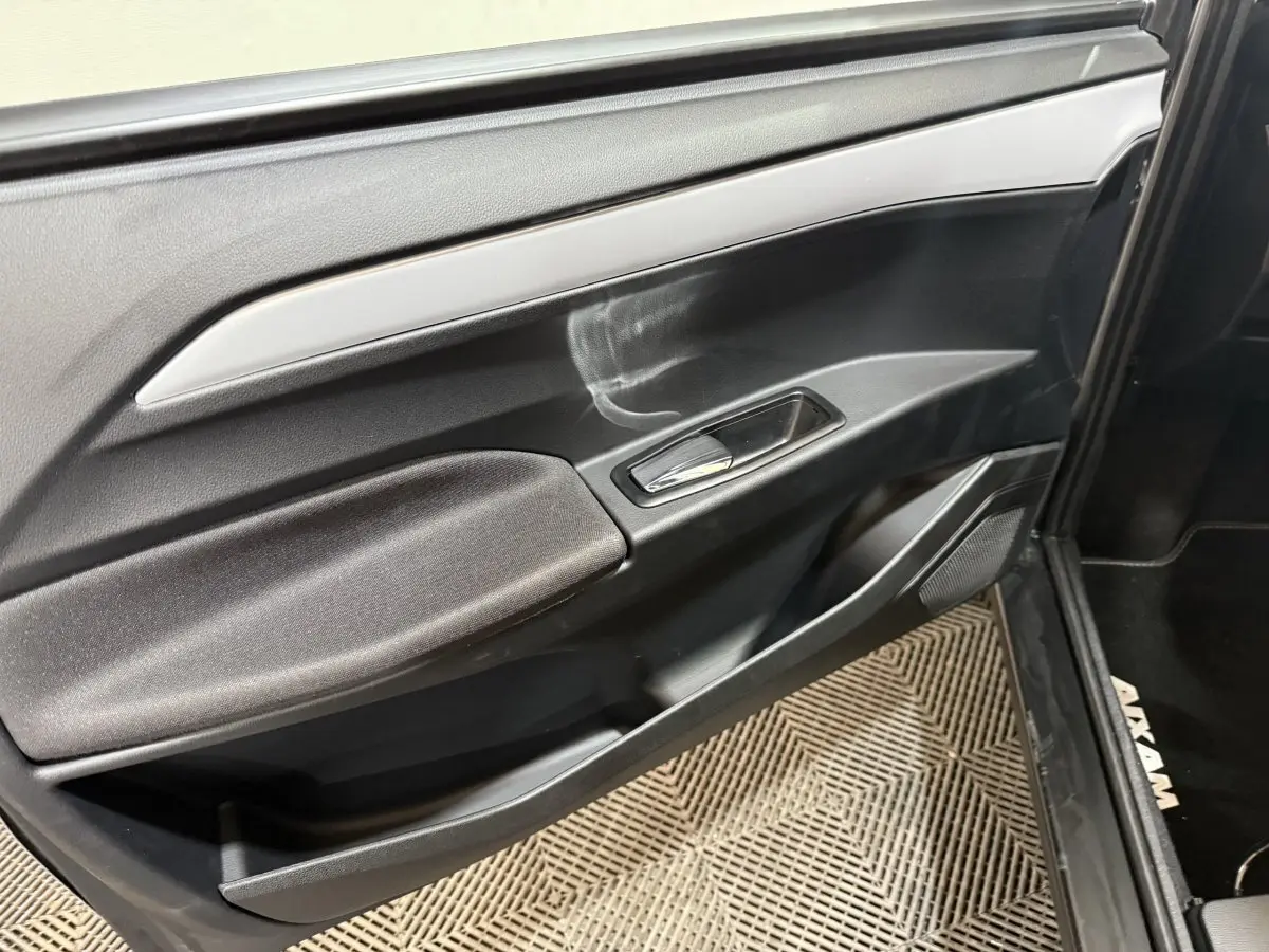 Détail de la porte côté conducteur de l’AIXAM Ambition 0.5 Crossover Premium 2026 en gris foncé, avec poignée et haut-parleur intégrés.