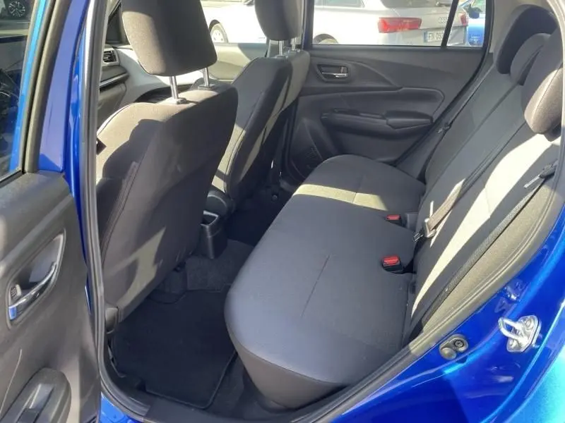 Vue intérieure côté gauche des sièges arrière d'une Suzuki Swift 2024 bleu métal, avec sellerie tissu noire et ceintures visibles.