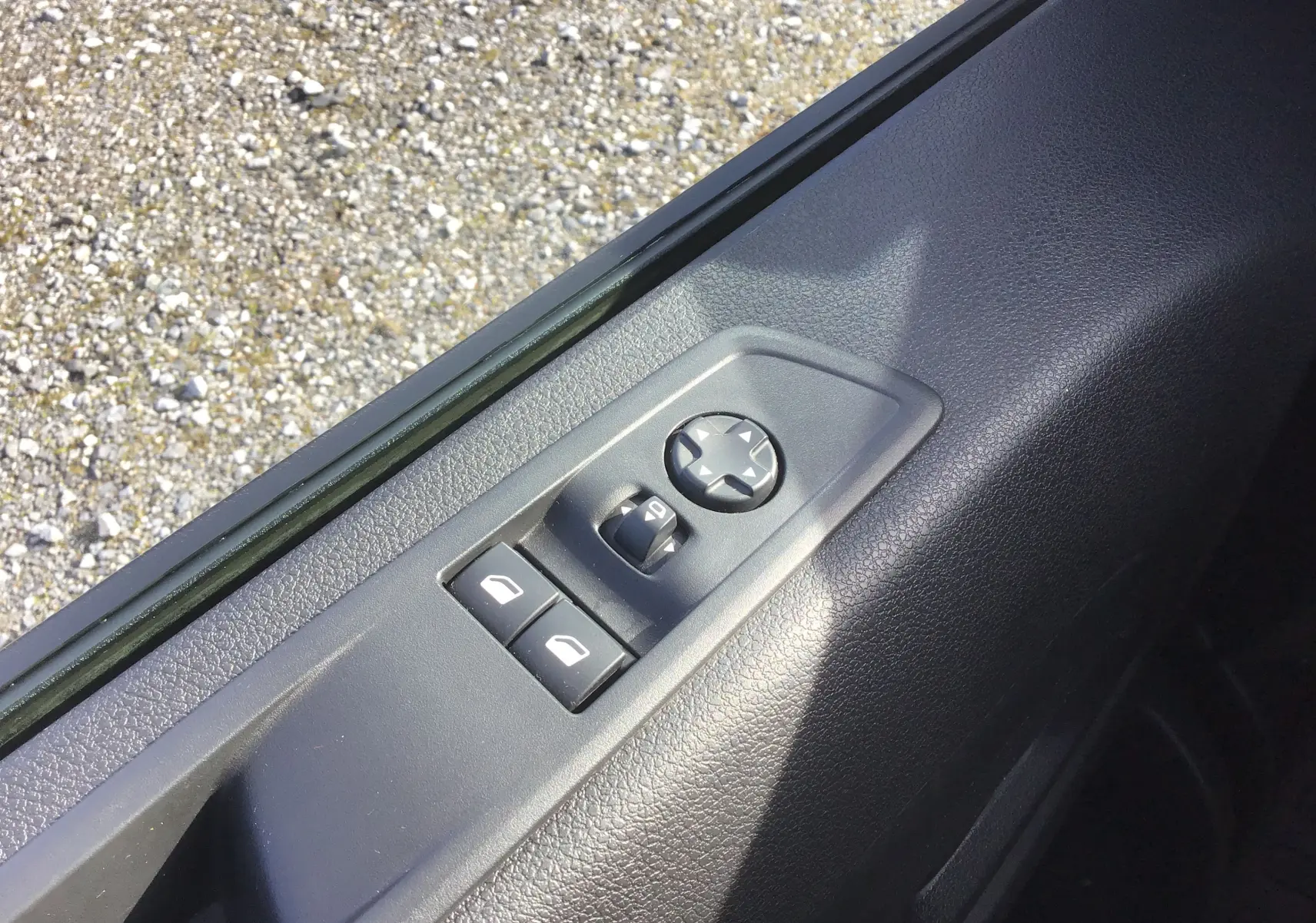 Gros plan sur les commandes de réglage des rétroviseurs et vitres côté conducteur du FIAT Scudo Fourgon blanc 2024.