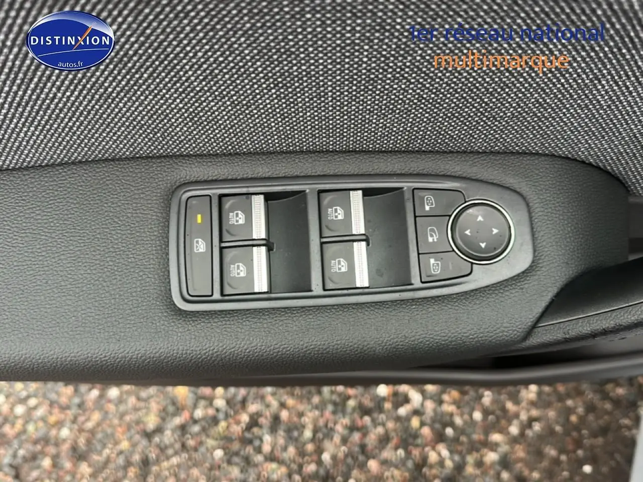 Gros plan sur les commandes de lève-vitres et rétroviseurs côté conducteur du Renault Captur gris rafale.