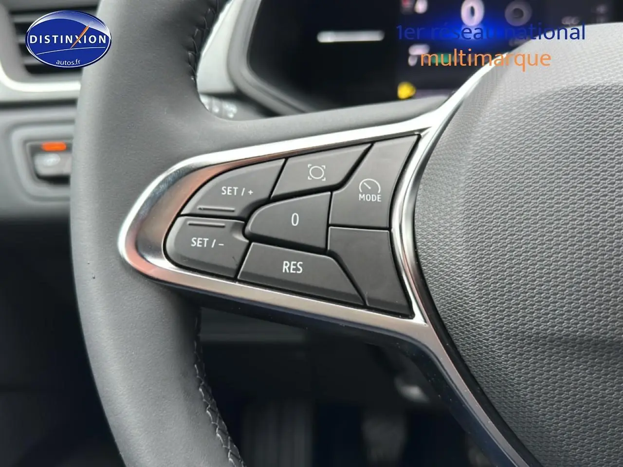 Gros plan sur les commandes multifonctions à gauche du volant du Renault Captur gris rafale, intérieur moderne.