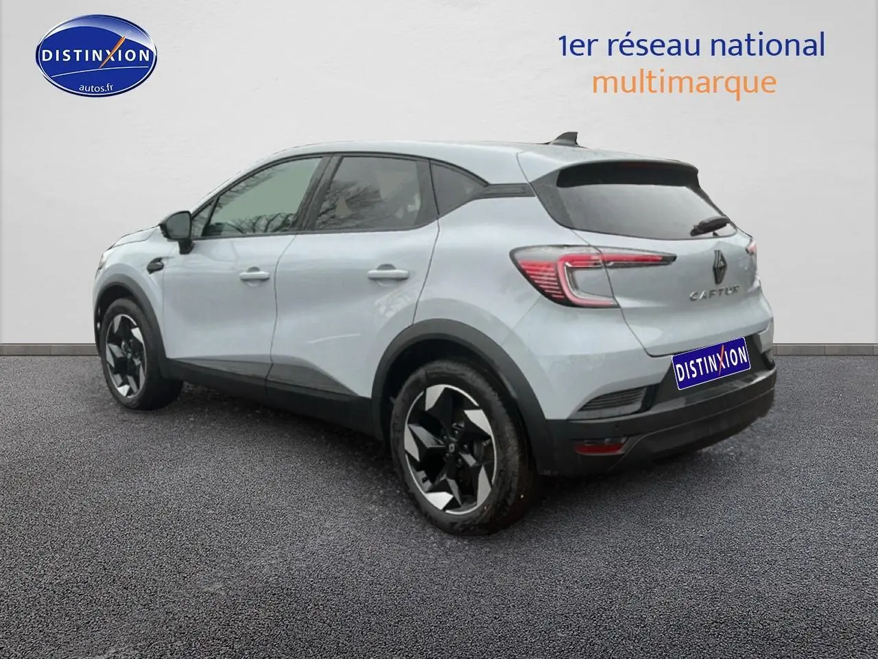 Vue 3/4 arrière droite d'un Renault Captur gris rafale avec jantes alu et feux arrière LED allumés.