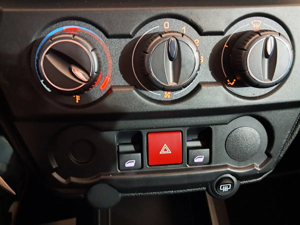 Détail du tableau de bord de l'AIXAM AMBITION 0.5 CITY COUPE GTI 2026 montrant les commandes de climatisation et les boutons de sécurité.