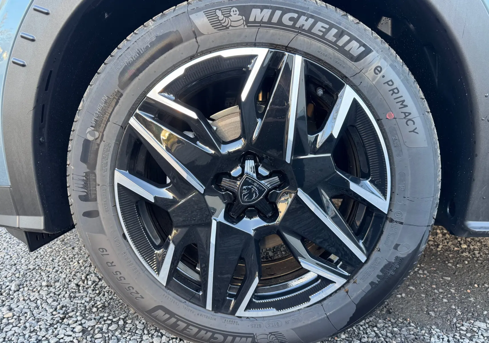 Gros plan sur la jante noire et argentée du Peugeot 3008 Bleu Nogaro, mettant en valeur le logo lion central.