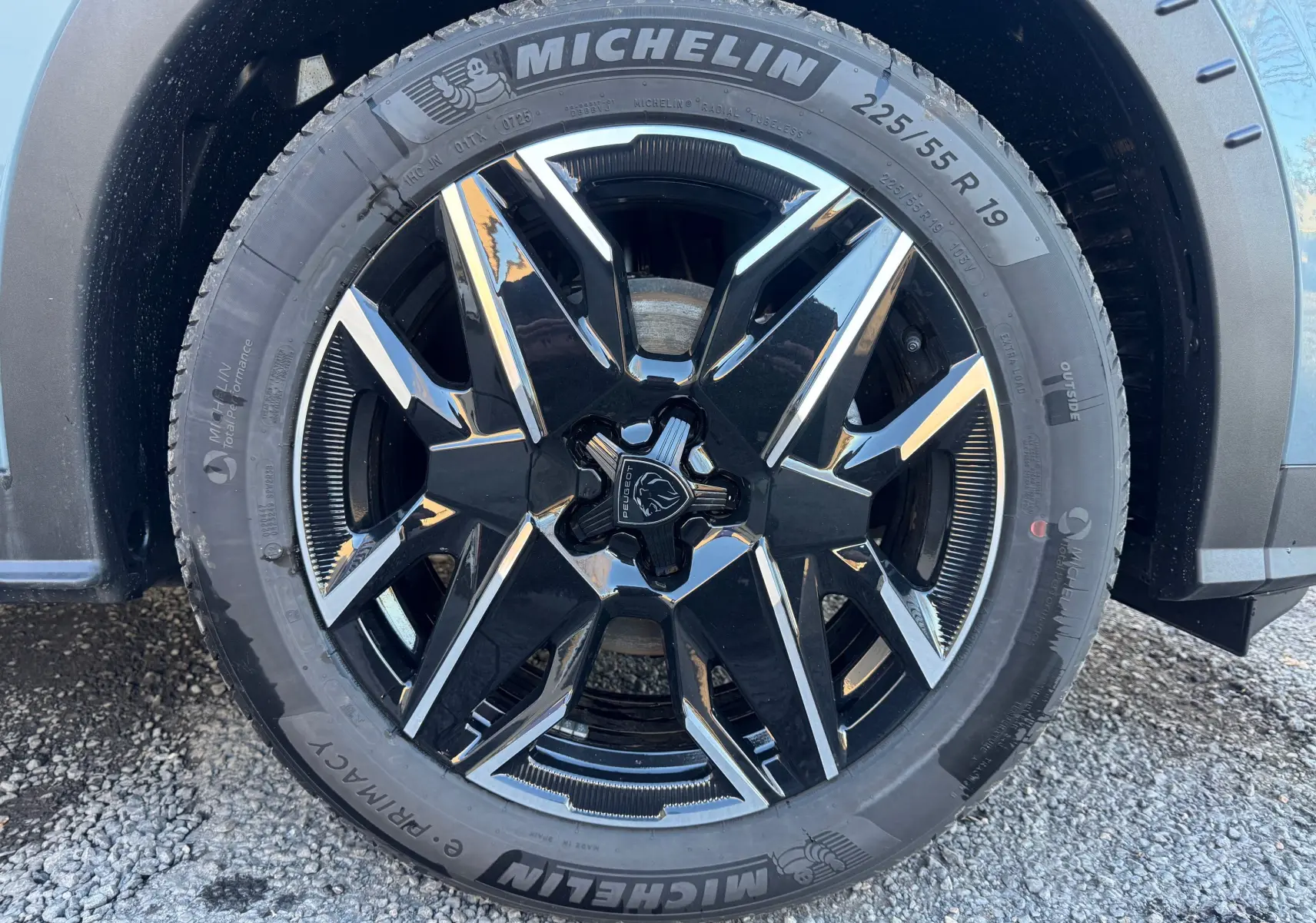 Gros plan sur la jante avant droite noire et argentée du Peugeot 3008 Hybrid 2025 Bleu Nogaro avec pneu Michelin.