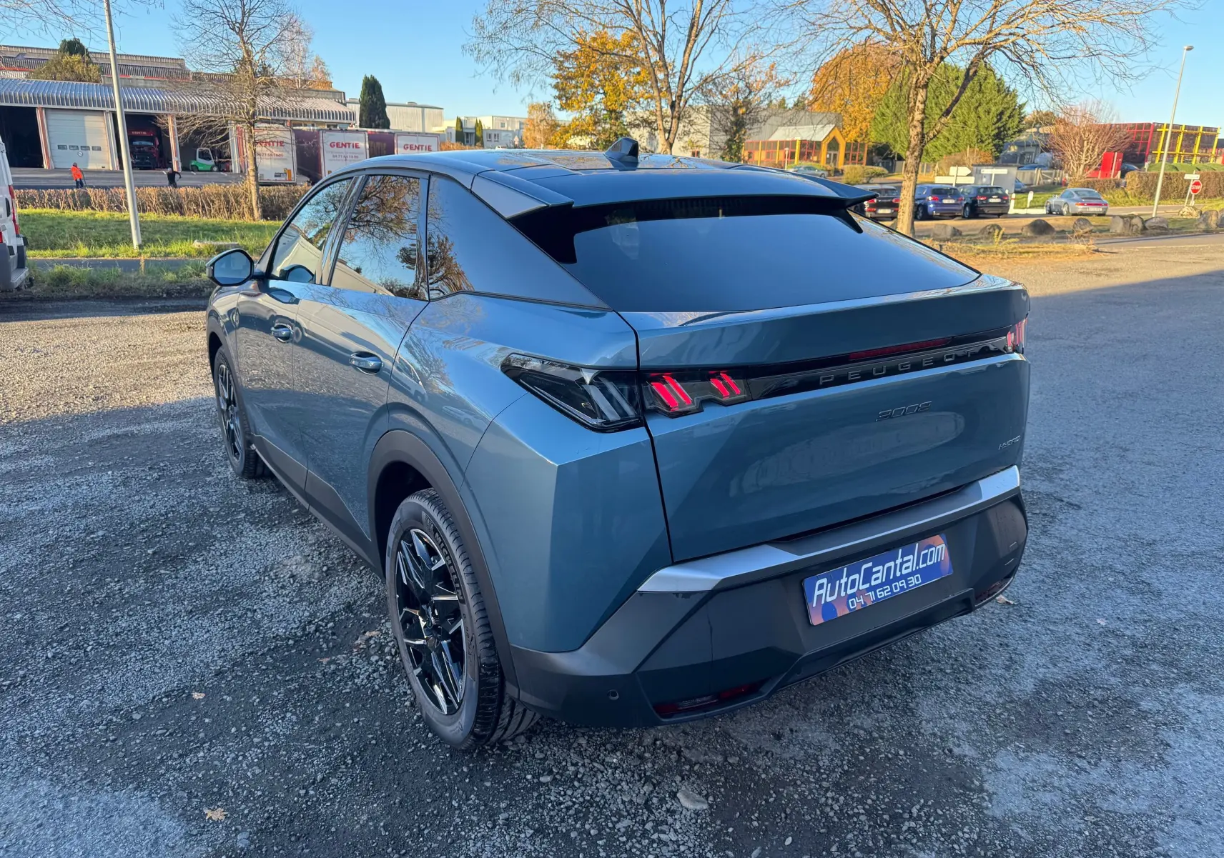 Vue 3/4 arrière droite du Peugeot 3008 Hybrid bleu Nogaro avec feux arrière LED distinctifs et toit noir brillant.