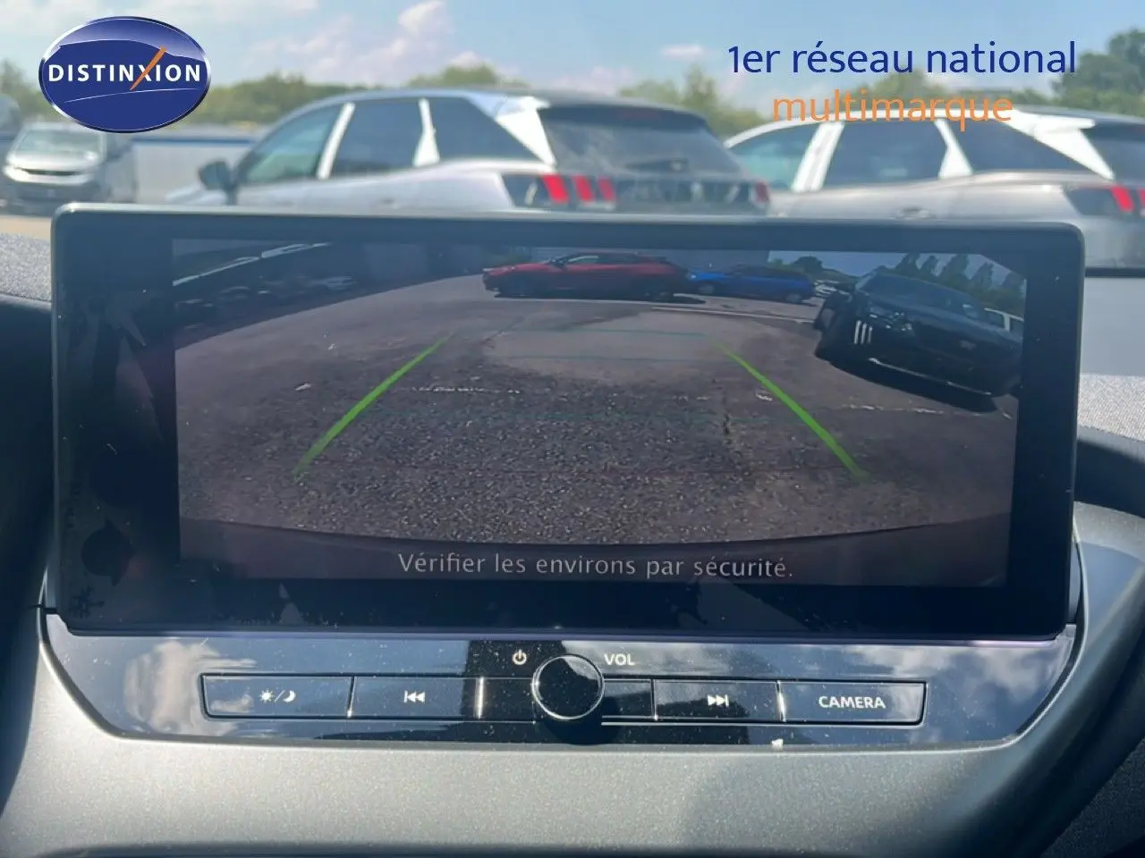 Écran central montrant la caméra de recul d’un Nissan Juke Hybrid gris, vue intérieure du tableau de bord.