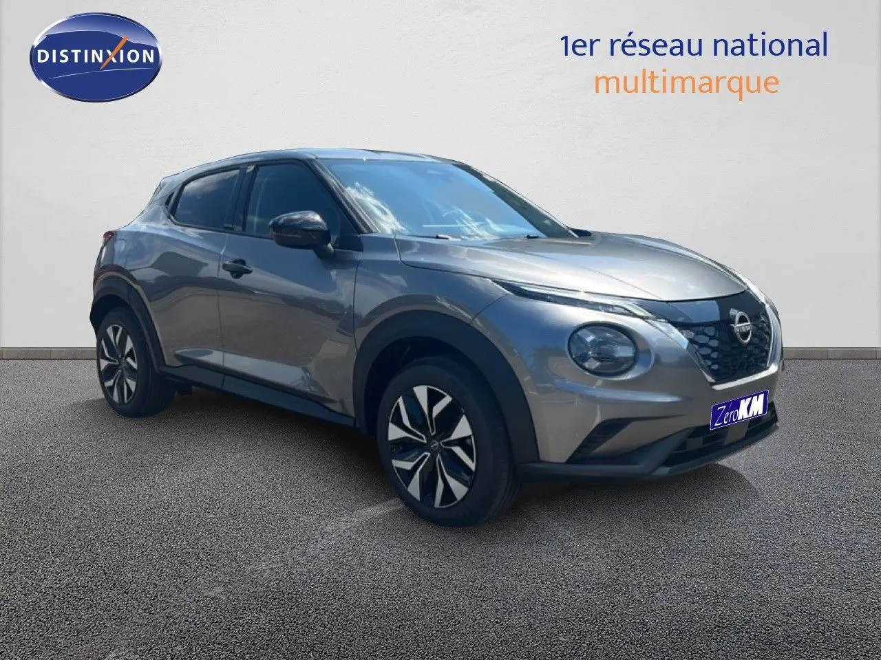 Vue 3/4 avant droit d'un Nissan Juke hybride gris squale métal avec jantes noires et détails modernes.