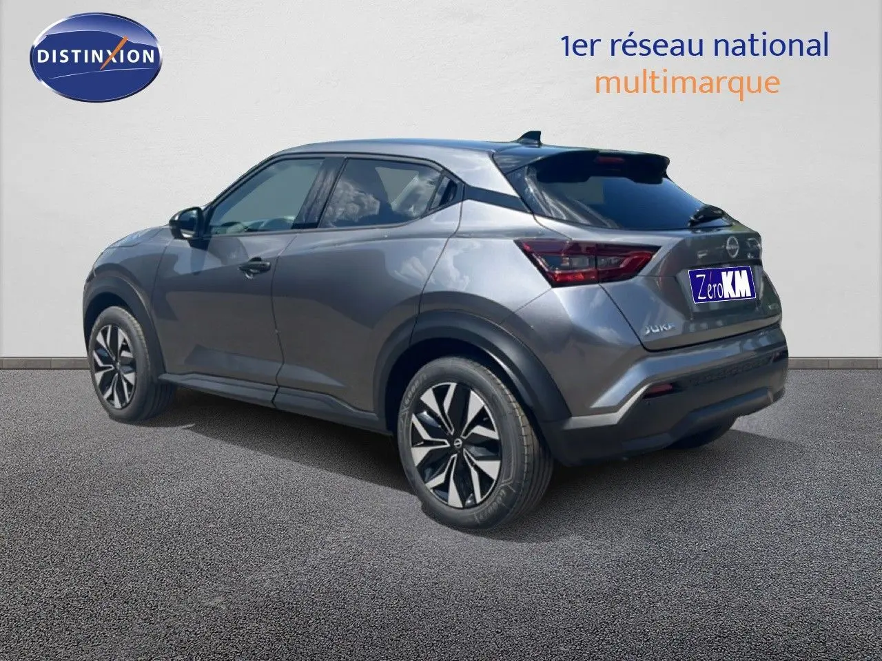 Vue 3/4 arrière droite du Nissan Juke Hybrid gris squale métal avec jantes noires et détails modernes.