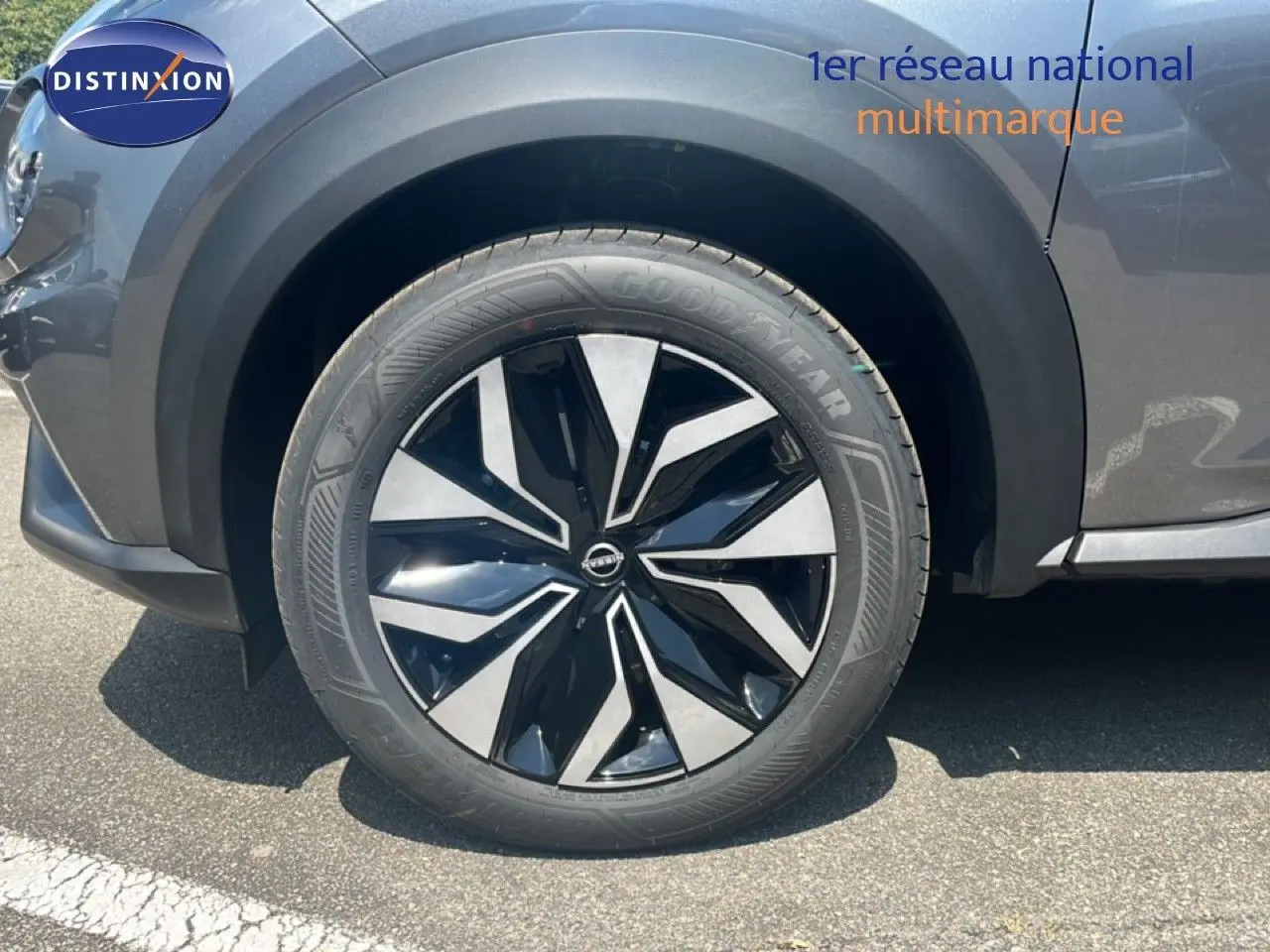 Gros plan sur la roue avant gauche du Nissan Juke gris squale métal, mettant en valeur la jante noire et argentée au design moderne.