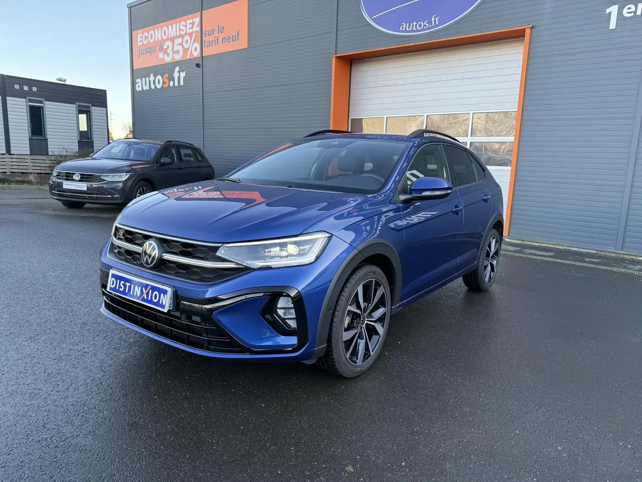 Volkswagen Taigo bleu récif métallisé en 3/4 avant droit avec jantes noires brillantes et calandre R-Line.