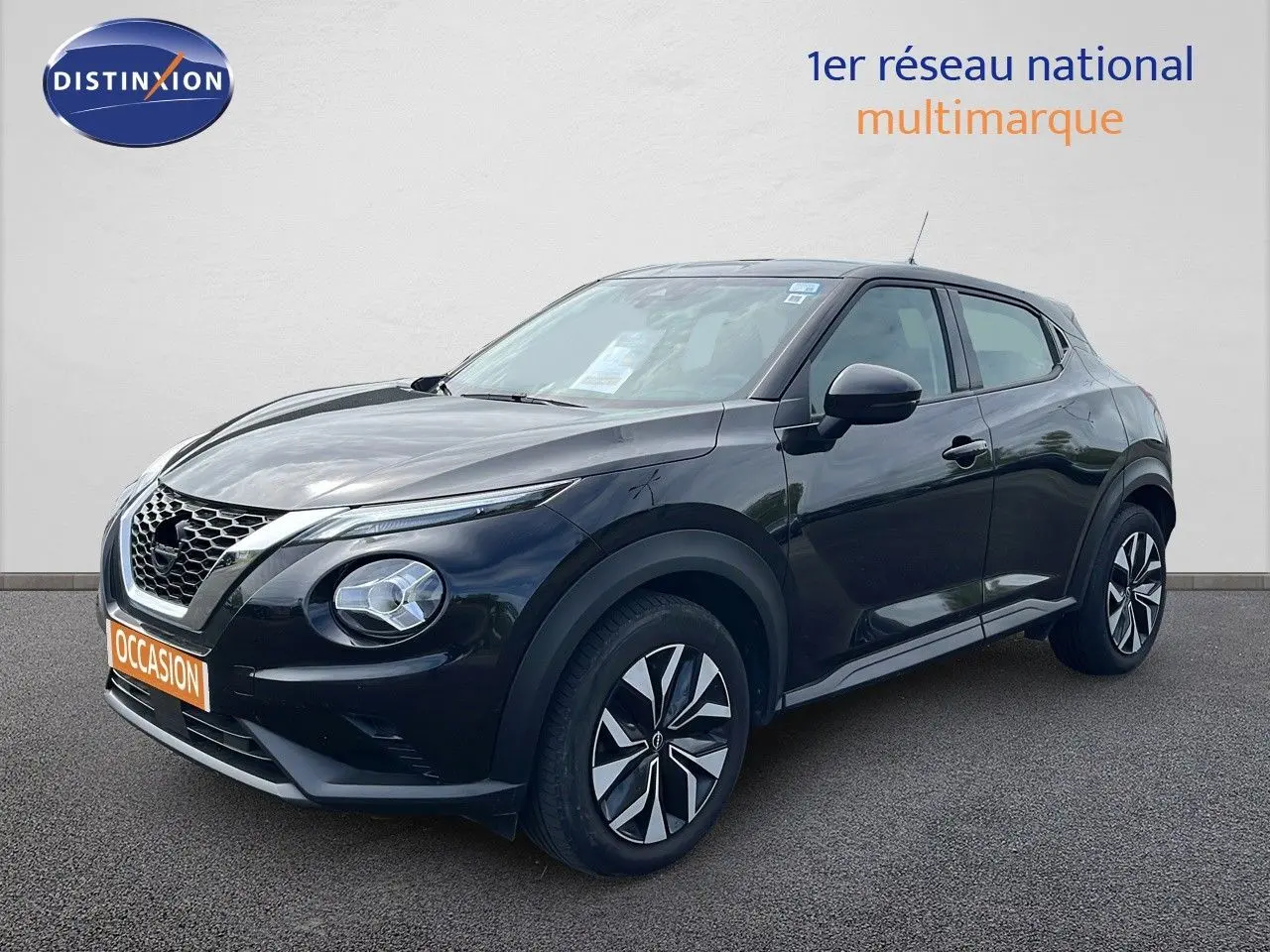 Nissan Juke noir métal en 3/4 avant droit, avec jantes stylisées et calandre distinctive en nid d'abeille.