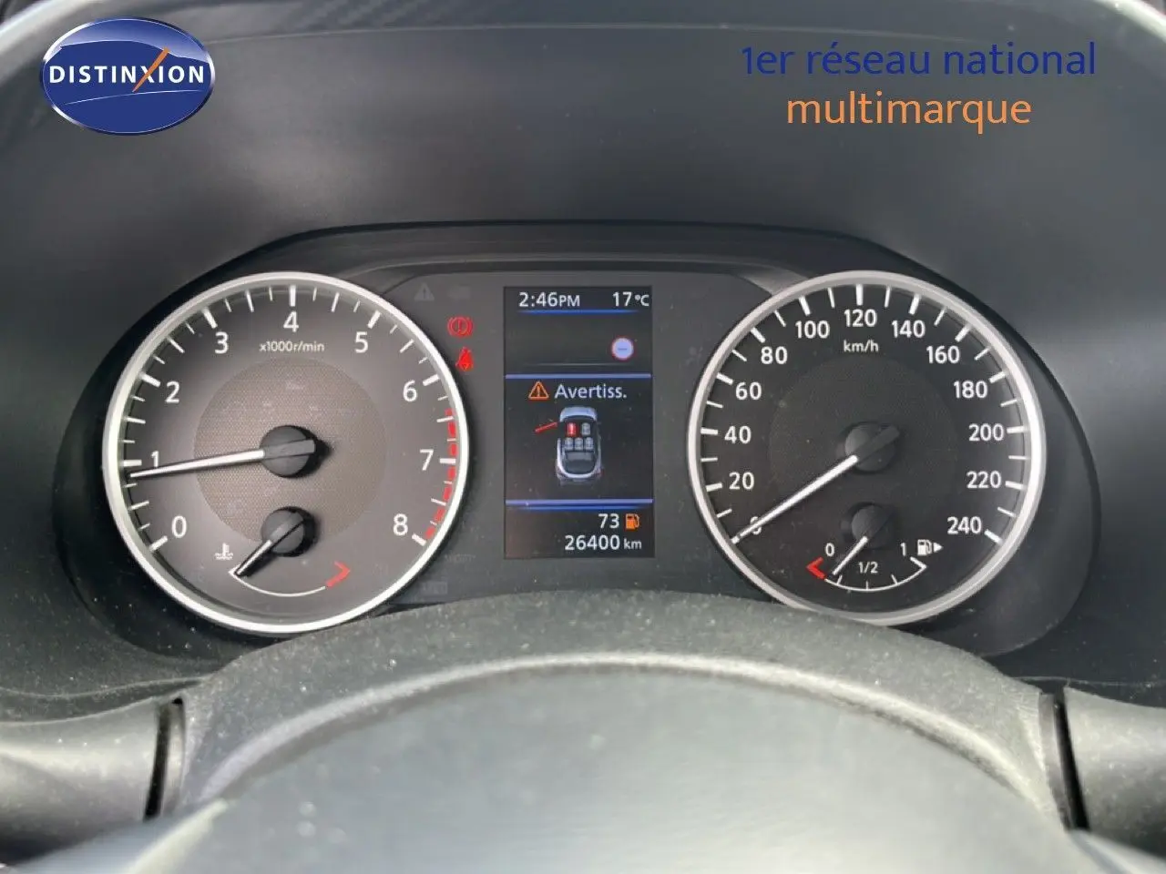 Vue rapprochée du tableau de bord du Nissan Juke 2023, affichant le compteur de vitesse et les alertes numériques.