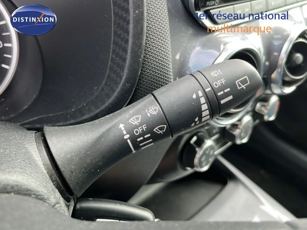 Gros plan sur la commande d’essuie-glace à gauche du volant dans l’habitacle noir du Nissan Juke 2023.
