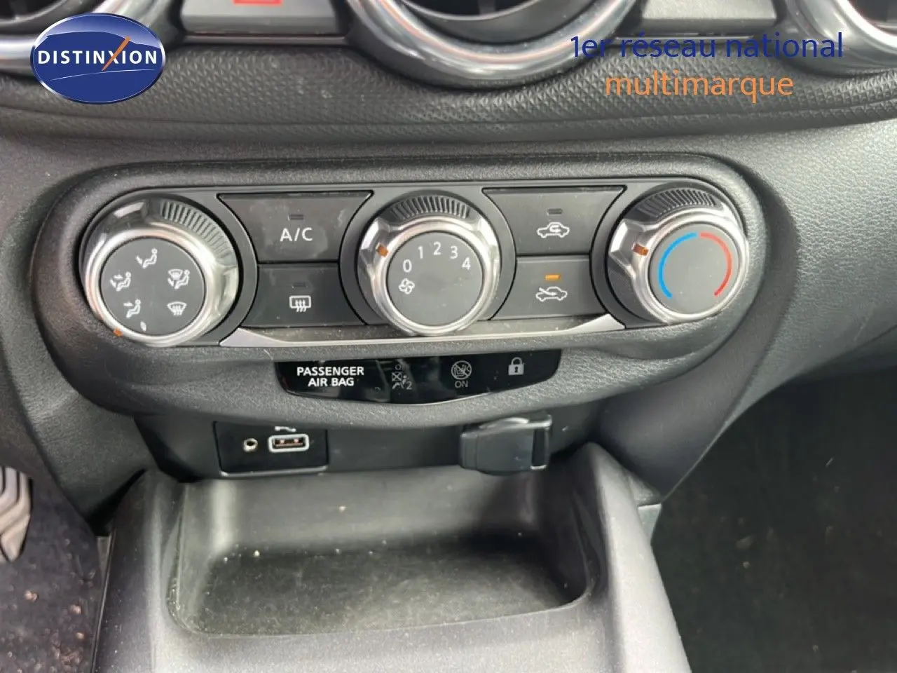 Gros plan sur les commandes de climatisation du Nissan Juke noir métal 2023, avec boutons rotatifs et affichage digital.