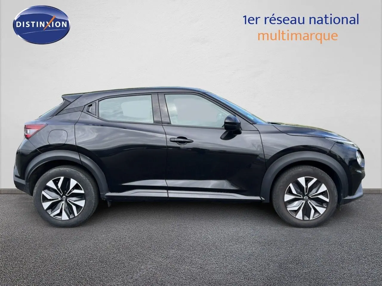 Profil côté gauche du Nissan Juke 2023 noir métal avec jantes distinctives et lignes dynamiques.