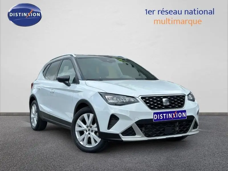 SEAT Arona blanc Nevada métal avec toit noir Minuit, vue 3/4 avant mettant en valeur la calandre et les jantes alu.