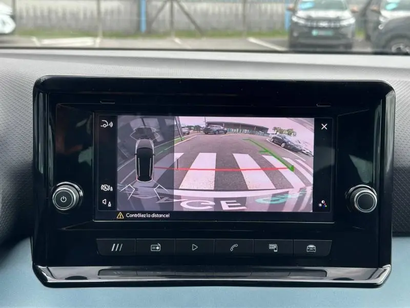 Écran tactile de la caméra de recul du SEAT Arona 2025, vue arrière avec lignes de guidage vertes et rouges.