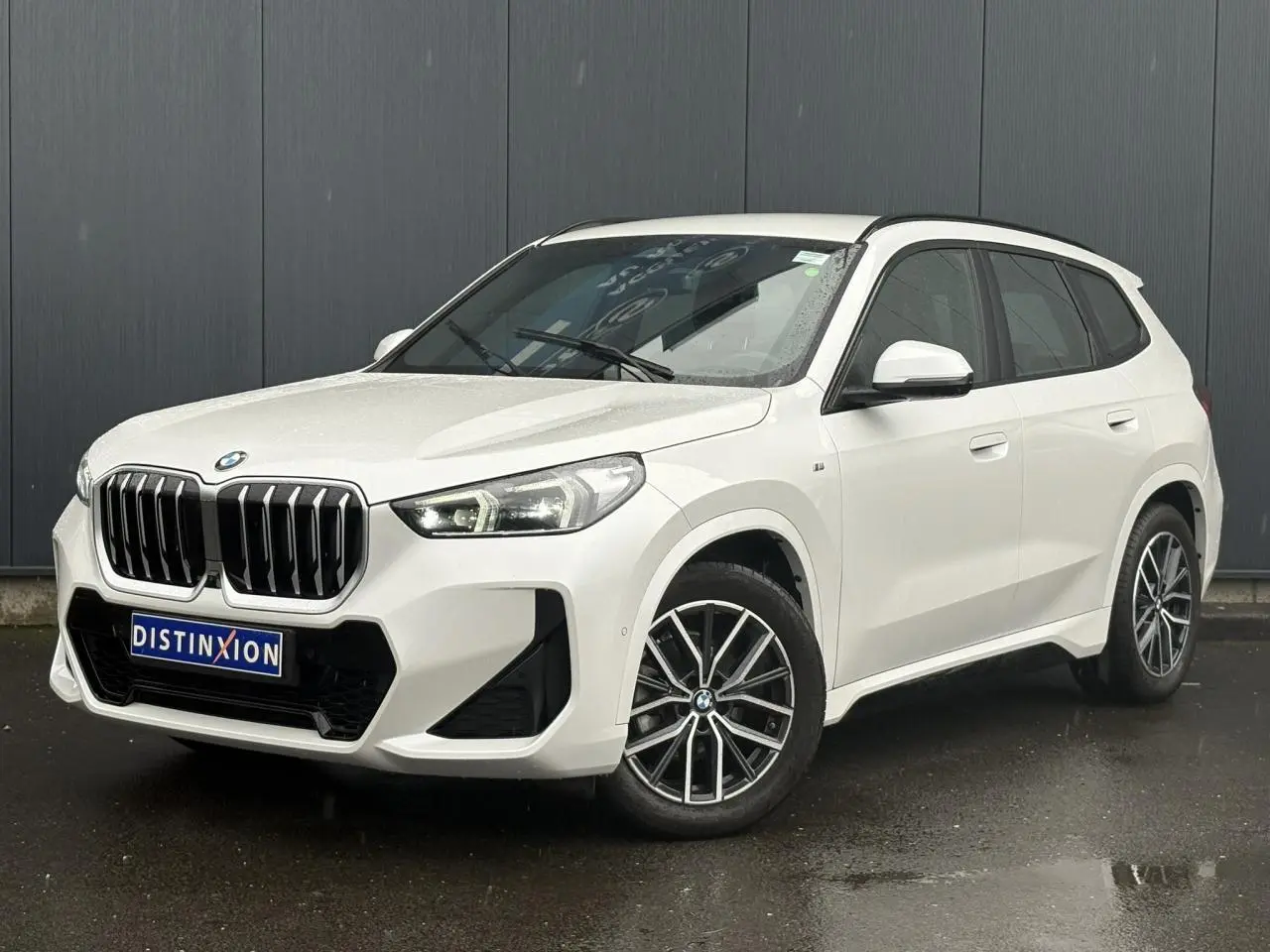 BMW X1 sDrive 20d blanc Mineral vue 3/4 avant, calandre imposante et jantes alliage bicolores visibles