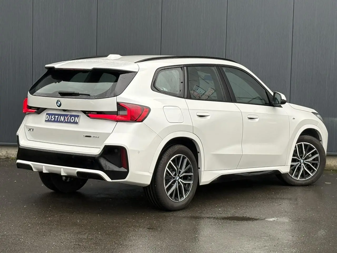 BMW X1 sDrive 20d blanc Mineral vue 3/4 arrière droit, jantes 18 pouces et feux LED distinctifs.