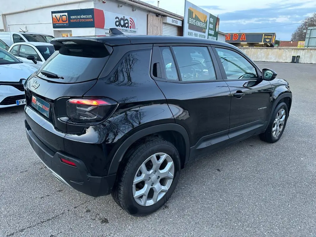 Jeep Avenger noir en vue 3/4 arrière droit, avec jantes alliage 17 pouces et feux arrière allumés.
