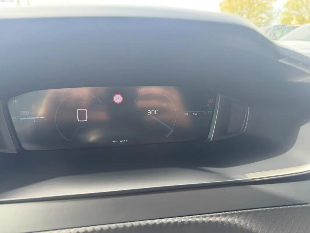 Vue rapprochée du cockpit numérique du Peugeot 2008 blanc 2024, affichant vitesse et compte-tours.