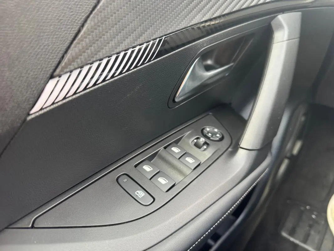 Gros plan sur la commande des vitres électriques côté conducteur de la Peugeot 2008 2024, finition Allure.