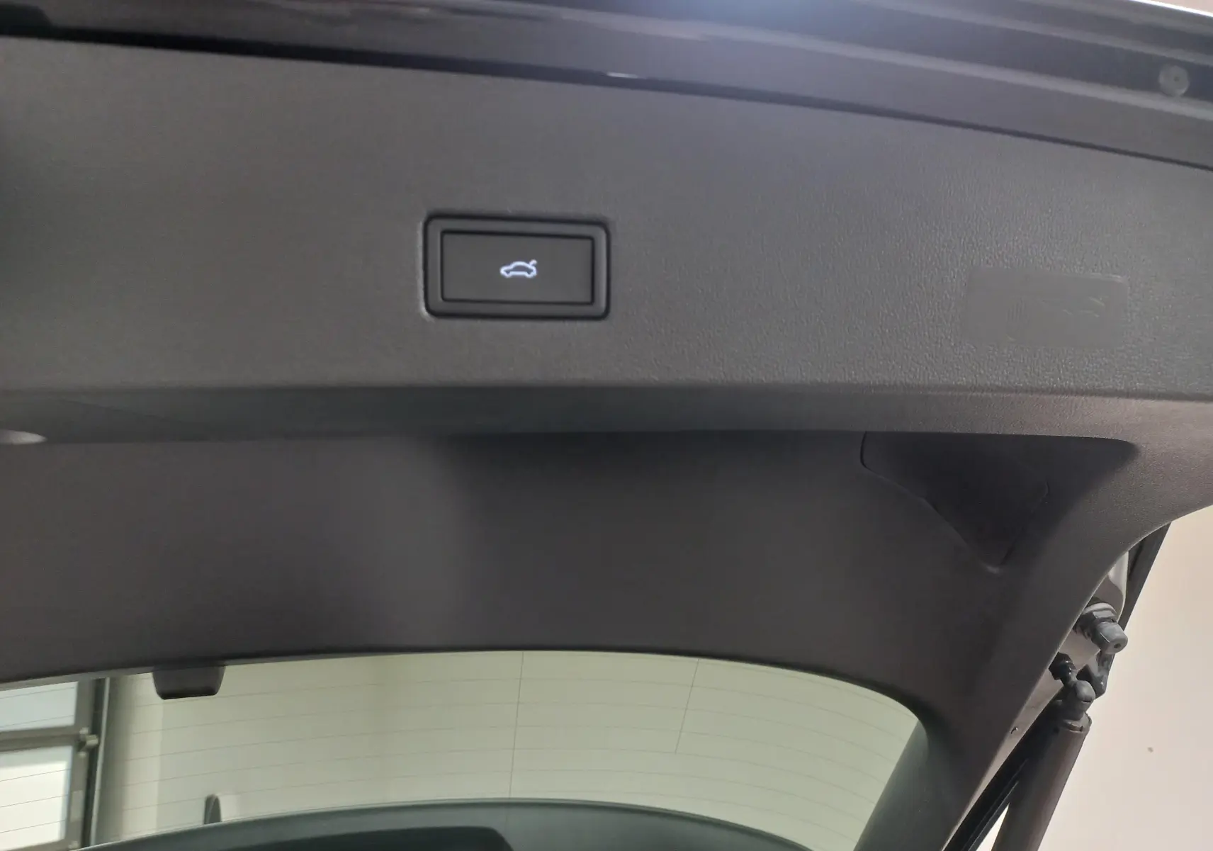 Détail du hayon électrique du Volkswagen T-Roc noir intense nacré, bouton d'ouverture main-libre visible.