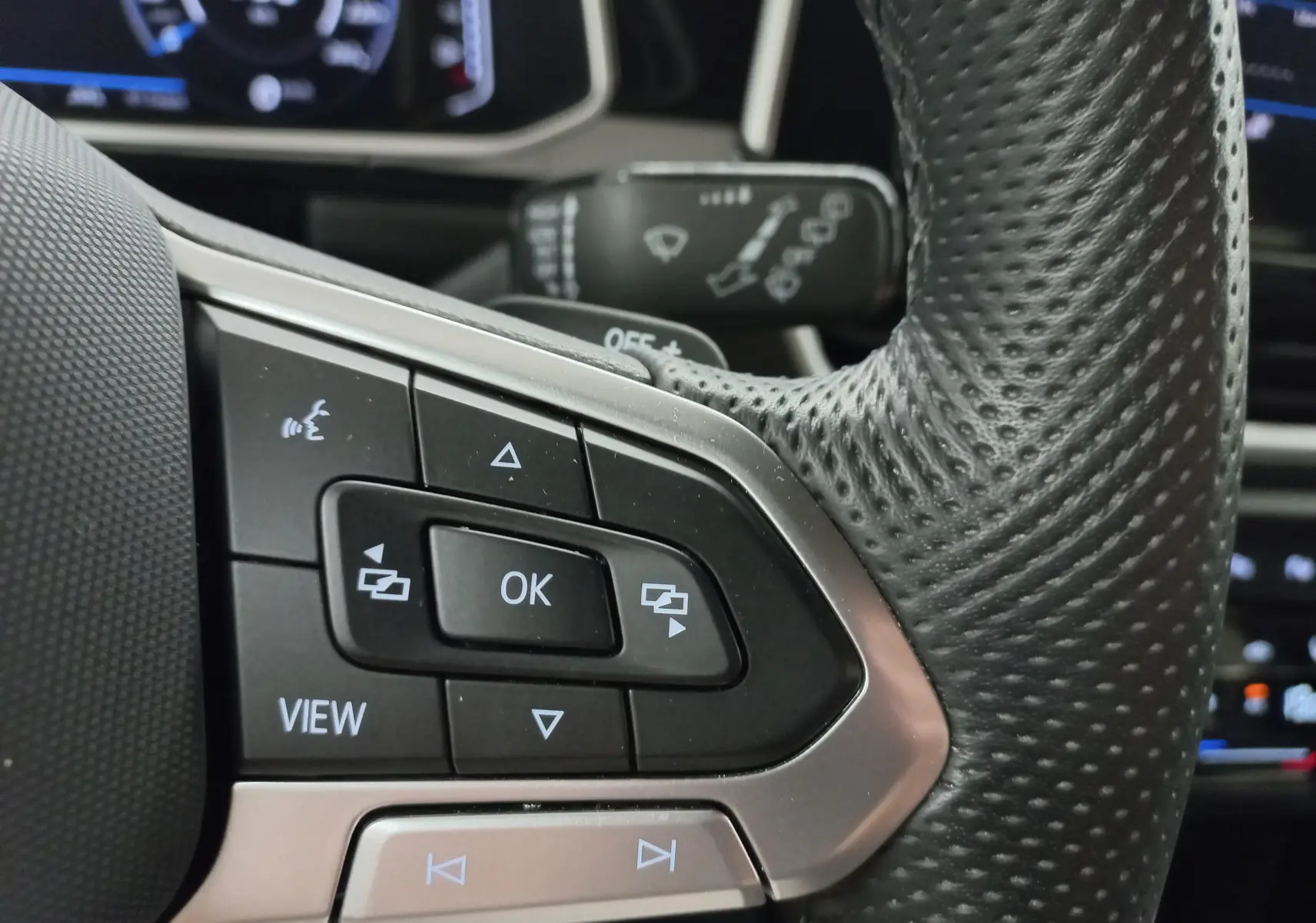 Gros plan sur les commandes au volant en cuir perforé du Volkswagen T-Roc 1.5 TSI 2025, finition R-Line.