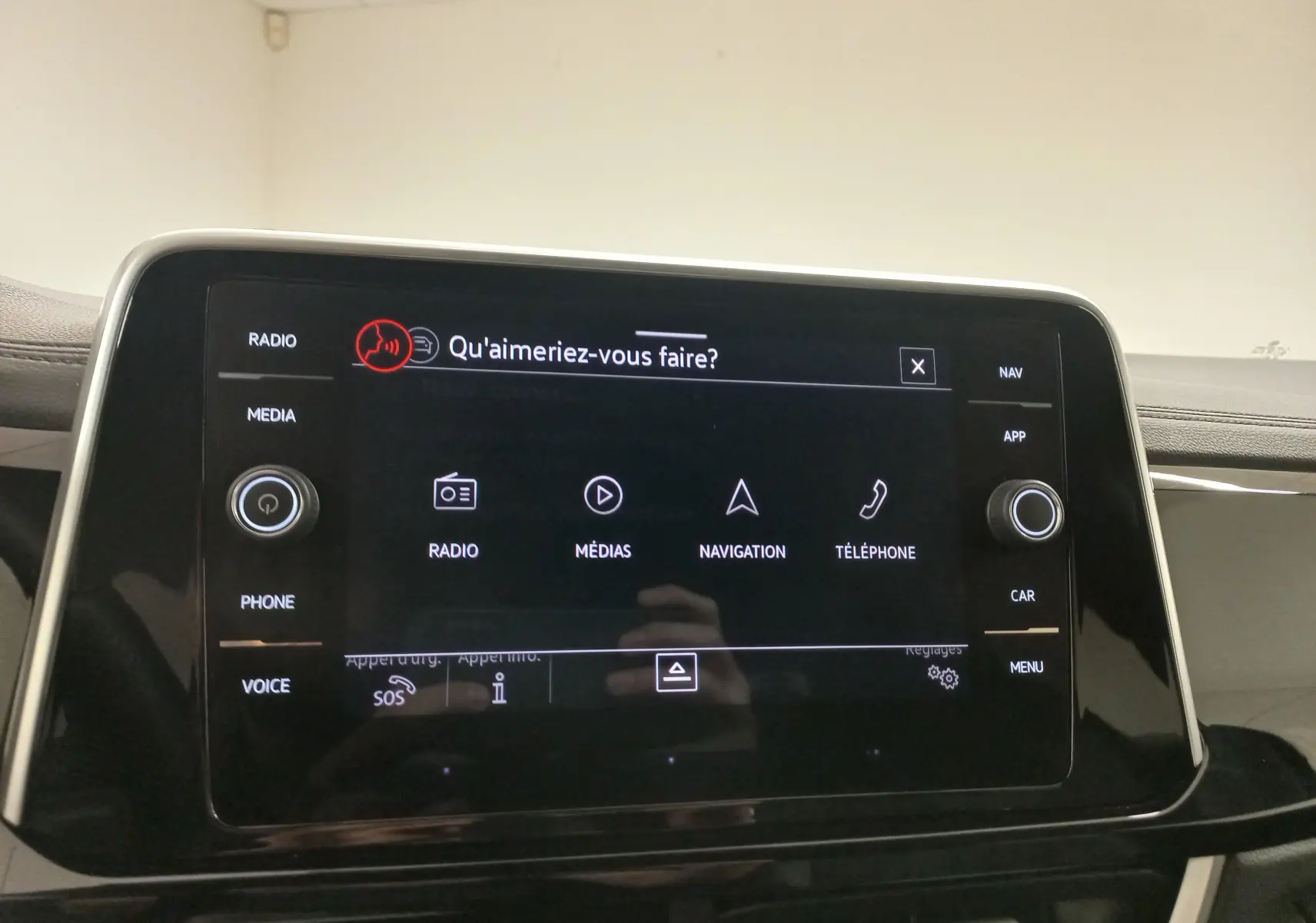 Écran tactile central du Volkswagen T-Roc 2025 avec interface vocale affichée, entouré de commandes physiques.