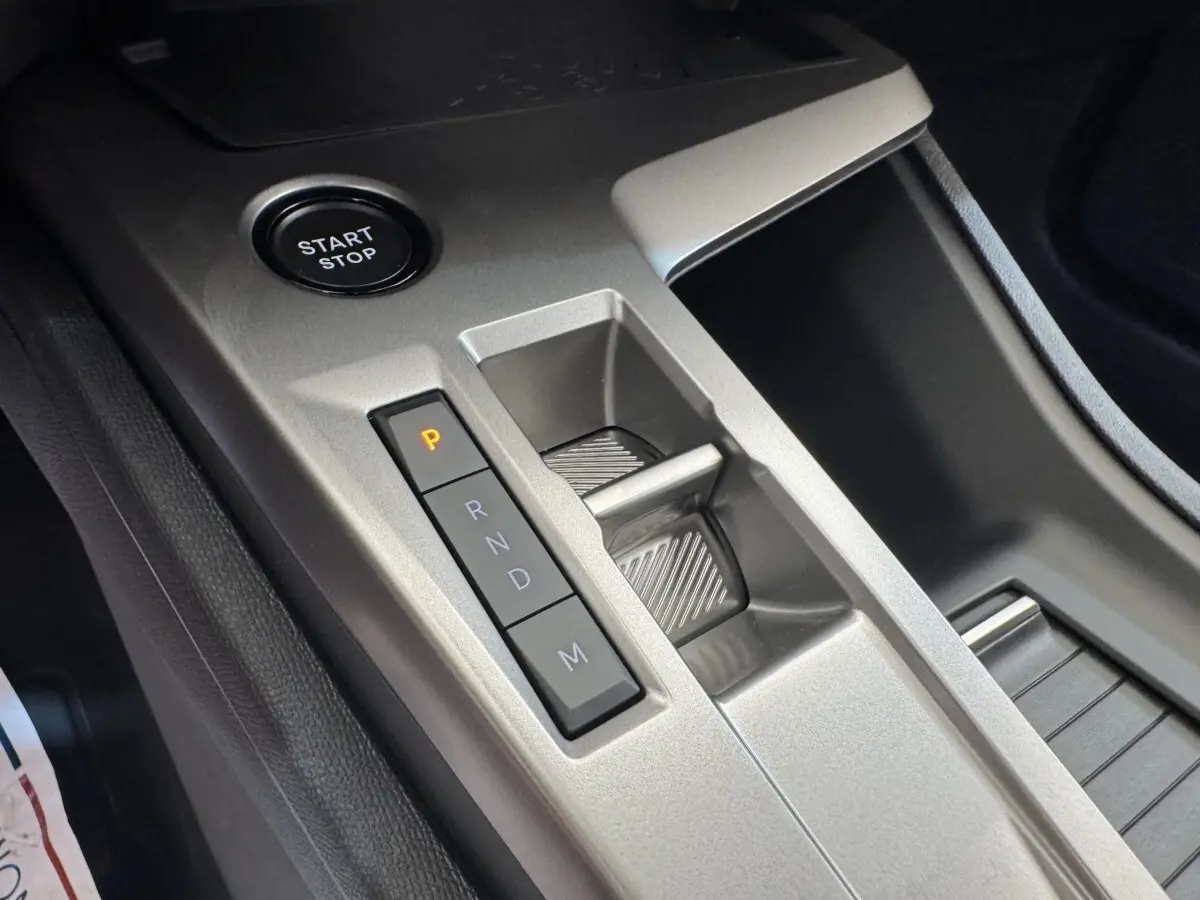 Gros plan sur la console centrale grise de la Peugeot 308 2026, avec bouton Start/Stop et commande de boîte auto.