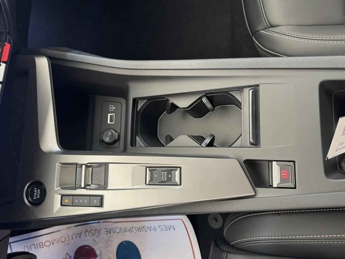 Vue rapprochée de la console centrale grise claire de la Peugeot 308 2026 avec bouton start/stop et commandes boîte auto.