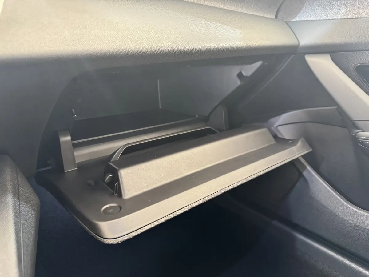 Vue intérieure côté passager montrant la boîte à gants ouverte du Peugeot 308 gris clair 2026.
