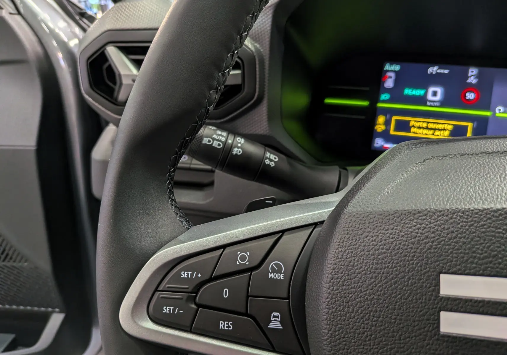 Gros plan sur le volant noir du Dacia Duster Hybrid-G 150 CH 4x4 2026 avec commandes multifonctions et tableau de bord numérique.