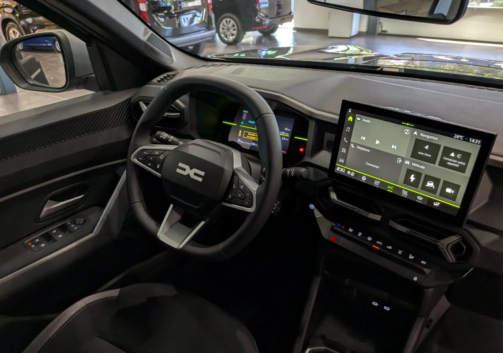 Vue intérieure côté conducteur du Dacia Duster Hybrid-G 150 CH 4x4 2026, avec tableau de bord numérique et écran tactile central.