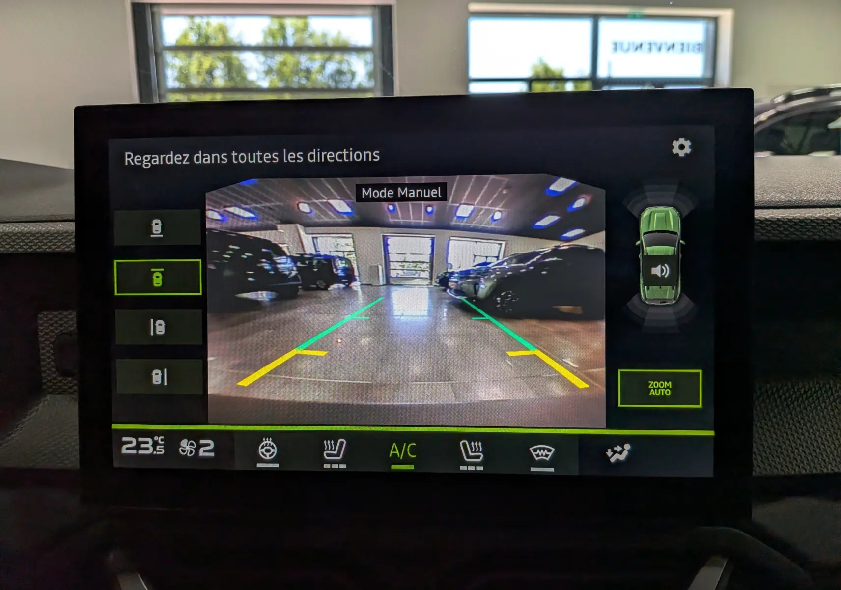Écran central montrant la caméra de recul du Dacia Duster Hybrid-G 150 CH 4x4 gris schiste en mode manuel, avec guidage de trajectoire.