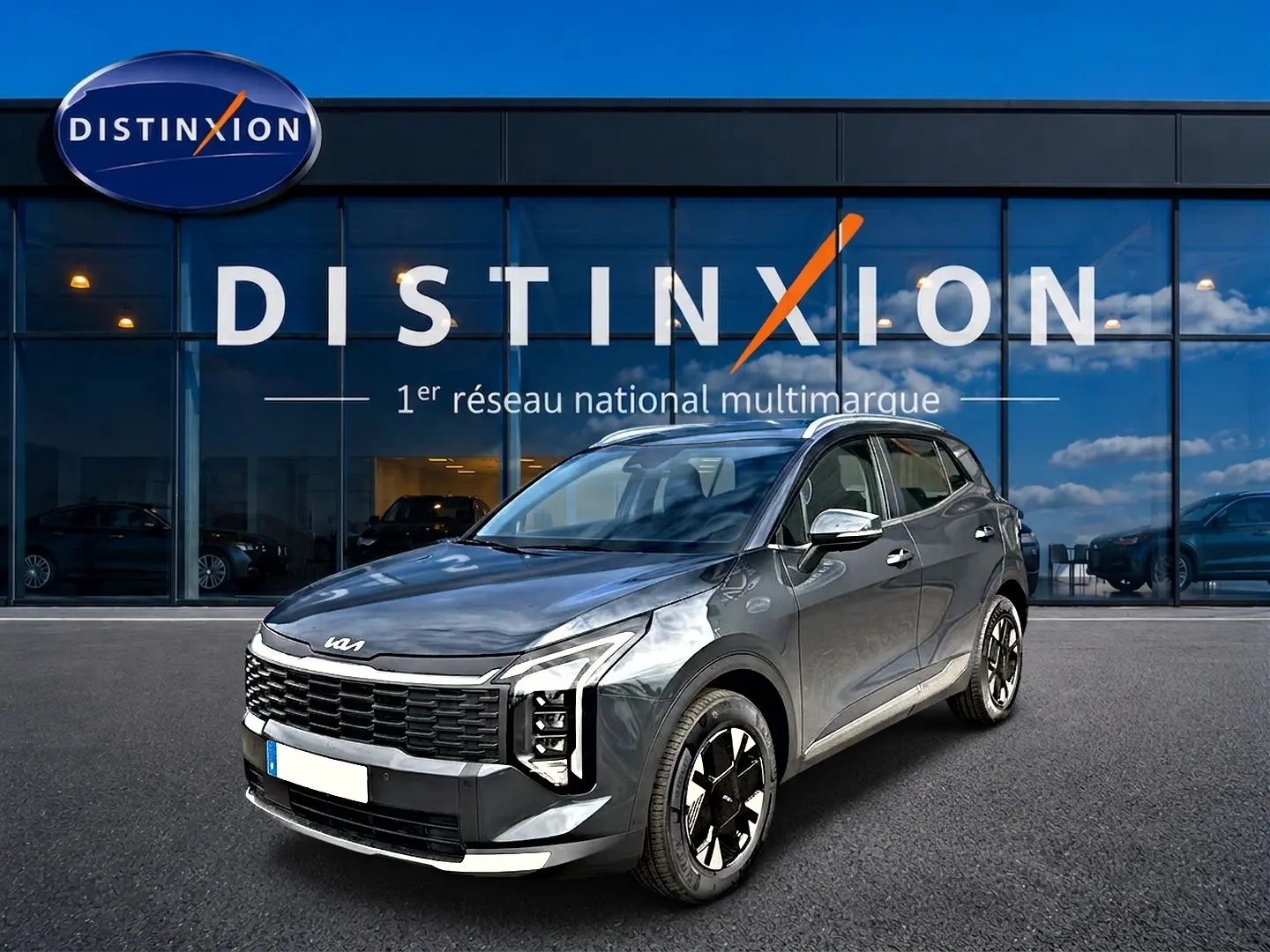 KIA Sportage 1.6 hybride gris eclipse en 3/4 avant droit, avec calandre noire et jantes alu 17 pouces design.