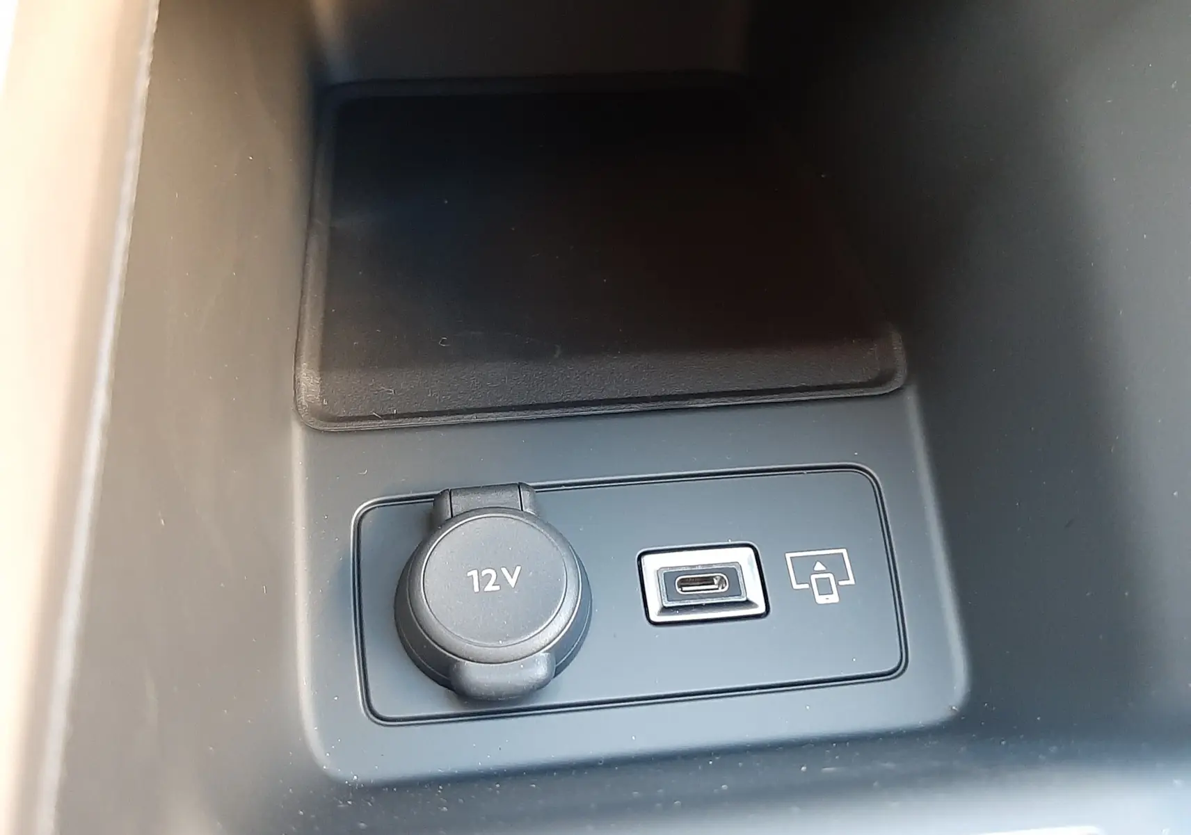 Prise 12V et port USB-C en gros plan dans la console centrale du Peugeot 308 Bleu Obsession 2025.