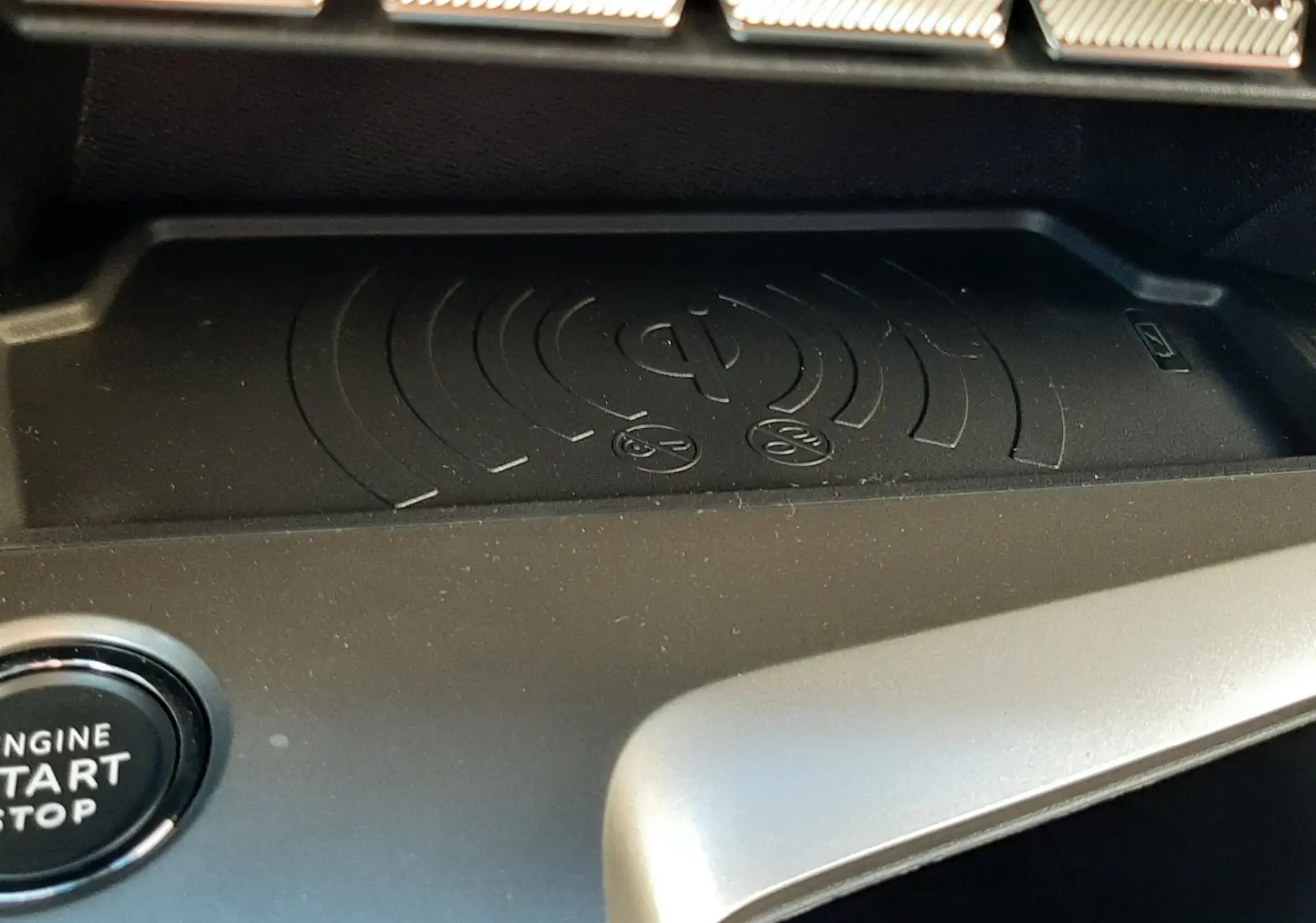 Détail de la console centrale du Peugeot 308 Bleu Obsession 2025 avec zone de charge sans fil et bouton start/stop.