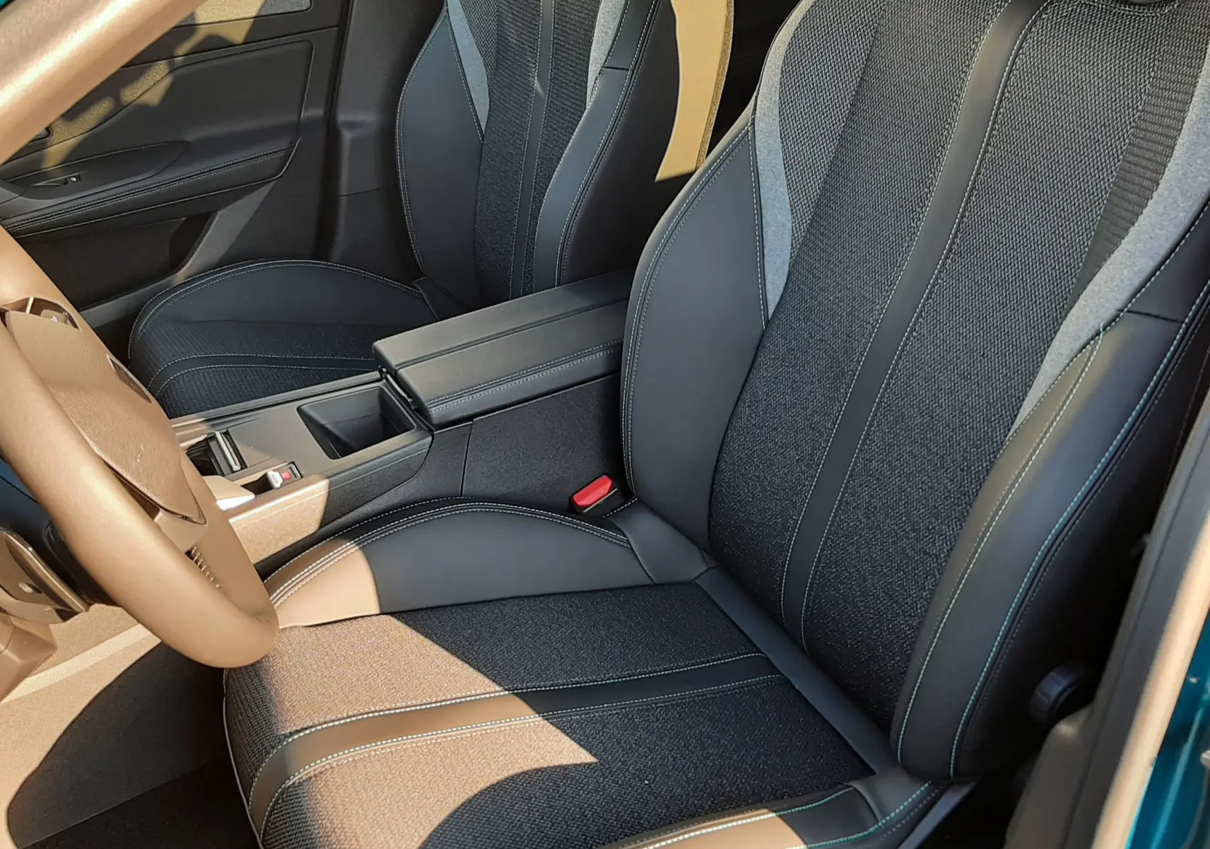 Vue intérieure rapprochée des sièges avant en tissu et cuir noir de la Peugeot 308 Bleu Obsession 2025.