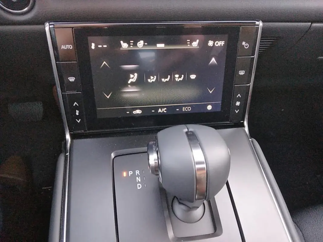 Gros plan sur la console centrale du Mazda MX-30 gris 2021, mettant en valeur le levier de vitesse automatique et l'écran tactile.