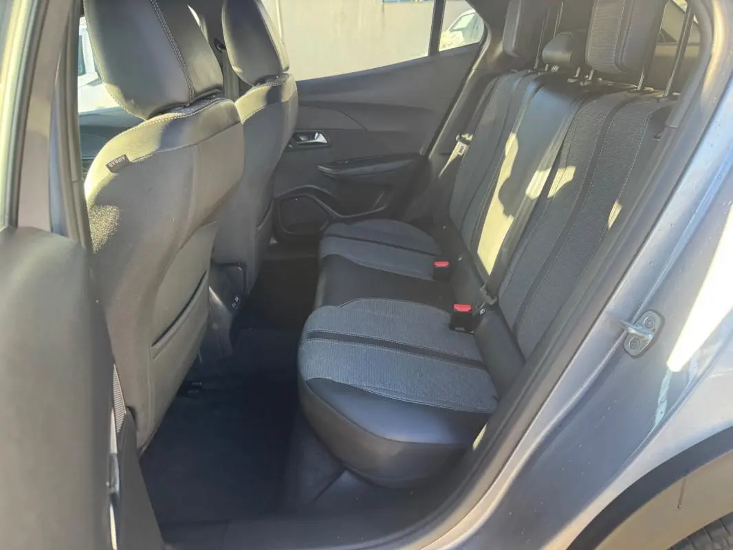 Vue intérieure arrière côté droit du Peugeot 2008 gris 2024, montrant les sièges arrière en tissu et cuir avec ceinture de sécurité.