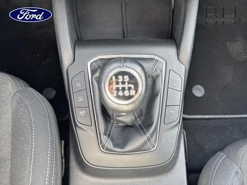 Gros plan sur le levier de vitesses manuel noir de la Ford Focus 1.0 EcoBoost 2020, entouré de commandes sur la console centrale.