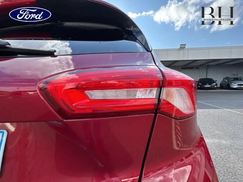 Gros plan sur le feu arrière droit d'une Ford Focus 1.0 EcoBoost 125ch rouge Premium Candy, avec vitre arrière surteintée.