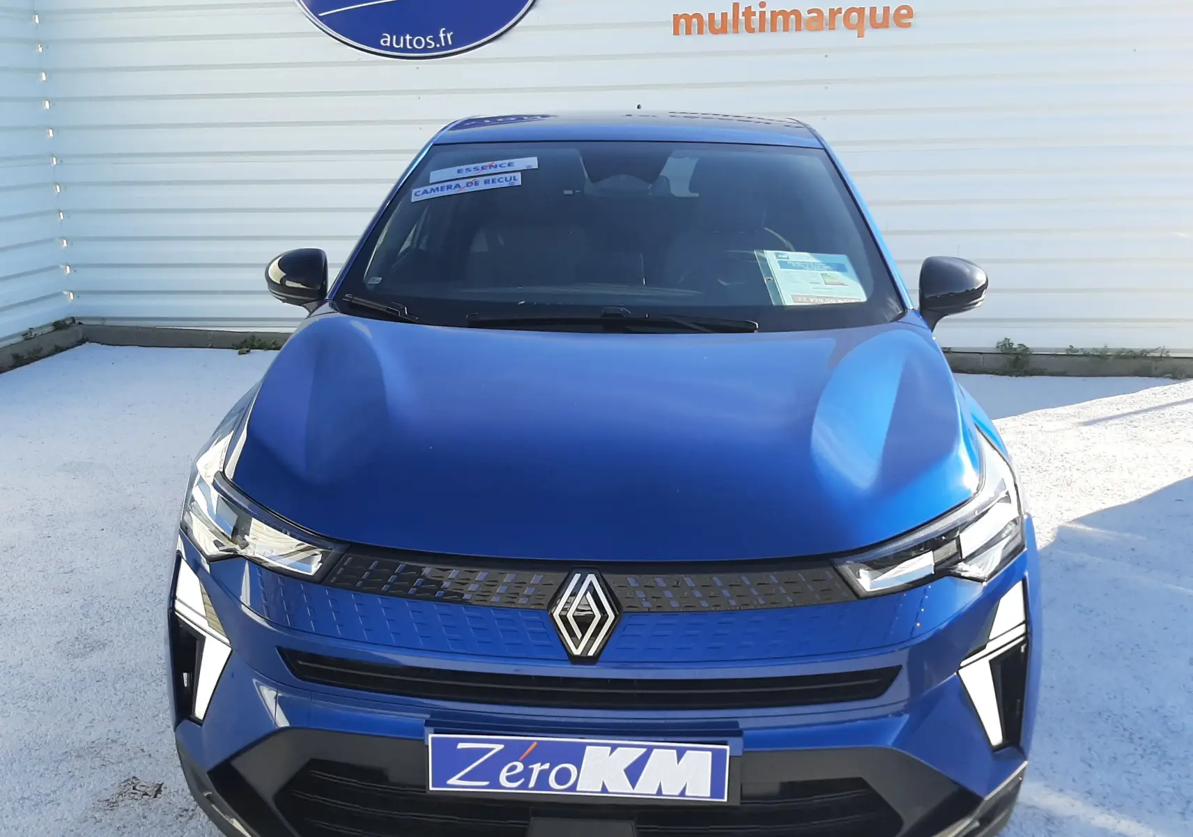 Vue frontale d'un Renault Captur II Ph.2 bleu Iron avec calandre noire et plaque Zero KM visible.