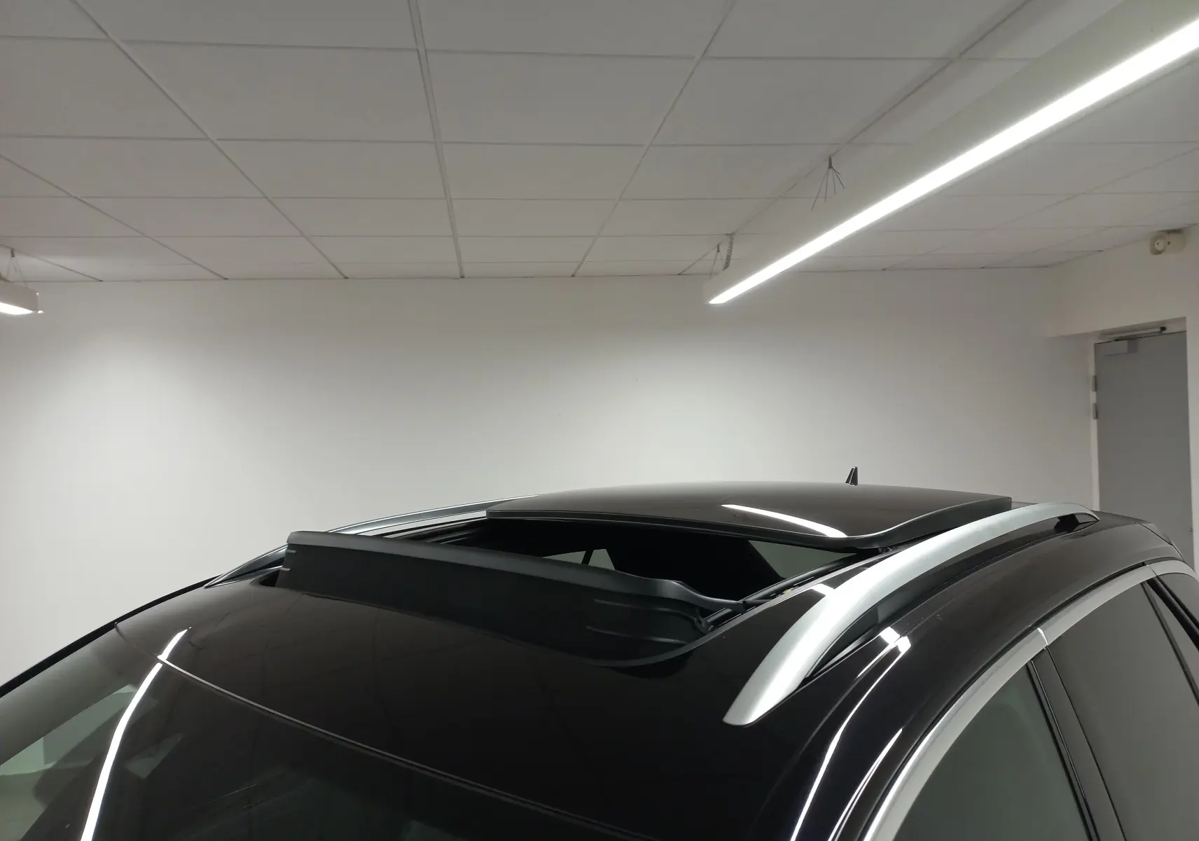 Toit ouvrant panoramique ouvert sur le dessus d’un Volkswagen T-Roc noir intense vu de trois quarts avant droit.
