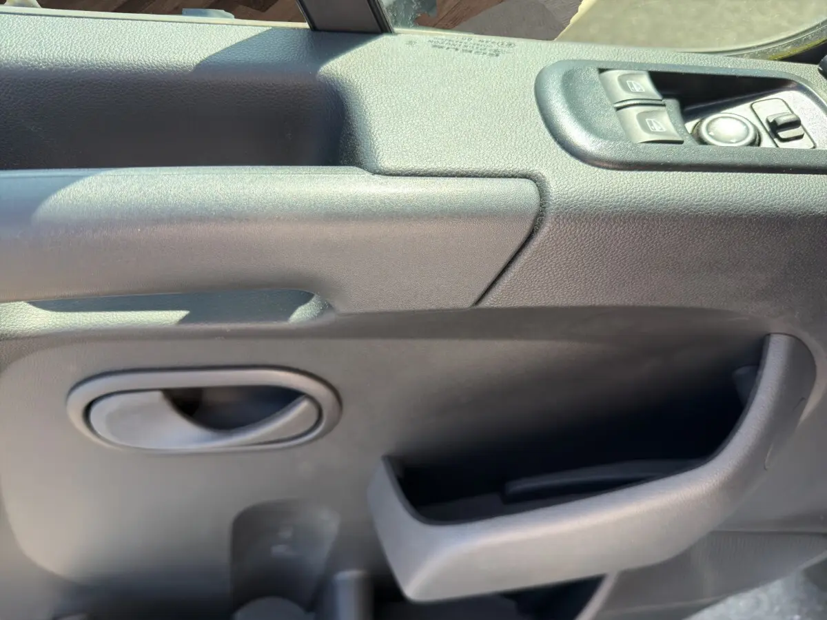 Gros plan sur la porte intérieure côté conducteur du Renault Master 2024, avec commandes électriques et poignée noire.