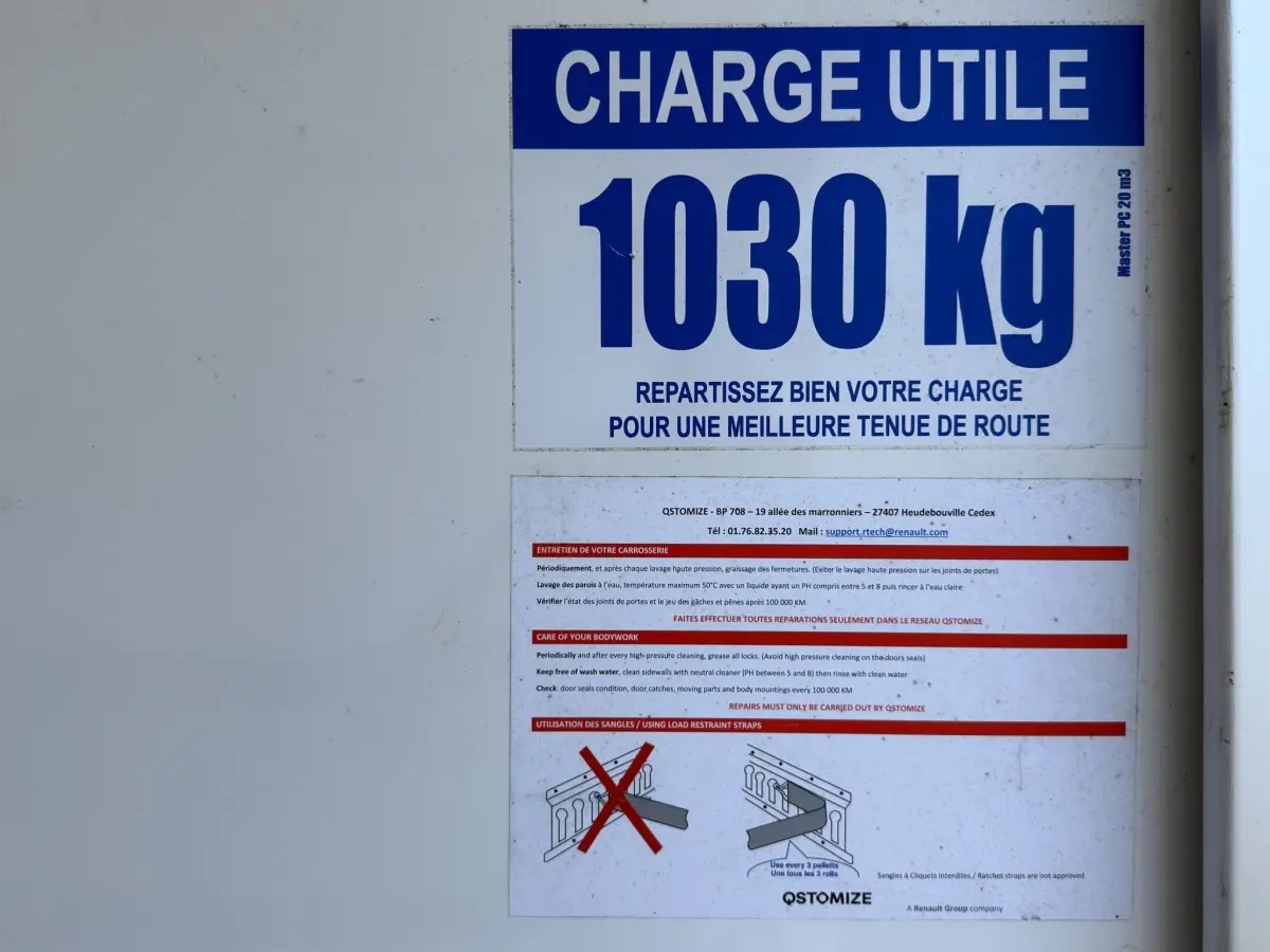 Panneau blanc indiquant la charge utile de 1030 kg sur un Renault Master utilitaire, vue frontale rapprochée.